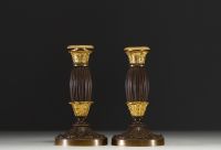 A pair of small gilt bronze candlesticks with a brown patina, from the Restoration period.
