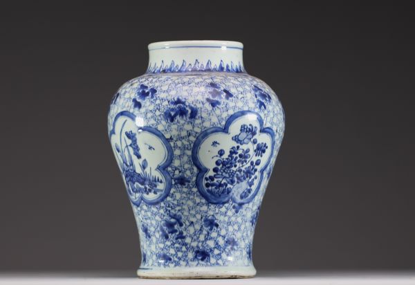 China - A white-blue porcelain baluster vase decorated with flowers, mugwort leaf mark within a double circle, Kangxi.
