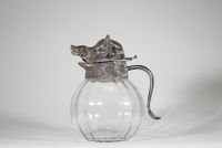 Valenti, Espagne, vers 1960 Aiguière en verre soufflé et monture en métal argenté à décor de sanglier.  Remarquable aiguière à panse godronnée en verre transparent, coiffée d’un couvercle sculptural en métal argenté figurant avec réalisme une tête de sanglier, gueule entrouverte et oreilles dressées.
