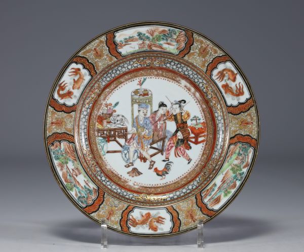 China - A polychrome porcelain plate, decorated with figures, animals and flowers, early 18th century.