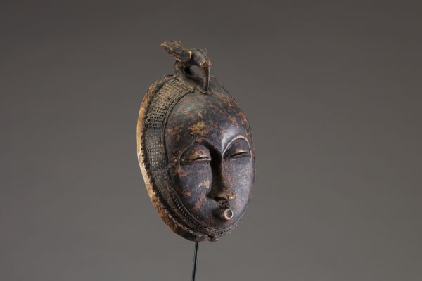 Afrique - Rare masque lune « Anglo Ba » Baoulé surmonté d’un animal, en bois dur sculpté, belle patine, Côte d’Ivoire, début XXème.