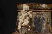 Villeroy & Boch  Mettlach - Imposante et rare jardinière en céramique à décor de personnages sur sa sellette en acajou. Vers 1900.