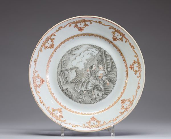Chine – Assiette en porcelaine de la Compagnie des Indes à décor peint en grisaille d’une scène érotique, XVIIIe siècle  Assiette en porcelaine décorée en grisaille et rehauts orangés, ornée au centre