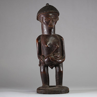 Statue de maternité, Lunda-Chokwe, zone frontière sud-est RDC / nord Angola. Bois sculpté, belle patine ancienne brune avec traces d’usage rituel, coiffe striée en casque avec crête, scarifications en losange et en chevrons, l'enfant saisissant activement le sein de sa mère. Cette statue constitue un témoignage remarquable d’un art de frontière entre les traditions Lunda, Chokwe et Luena, mêlant n