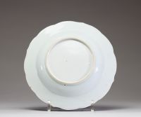 Chine – Assiette en porcelaine de la Compagnie des Indes à décor peint en grisaille et or d’une scène de famille, XVIIIe siècle. Charmante assiette à bord chantourné en porcelaine, décorée en grisaill