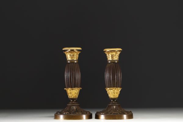 A pair of small gilt bronze candlesticks with a brown patina, from the Restoration period.
