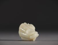 Chine - Pendentif en Jade blanc sculpté en forme de fruit surmonté d'un jeune enfant.