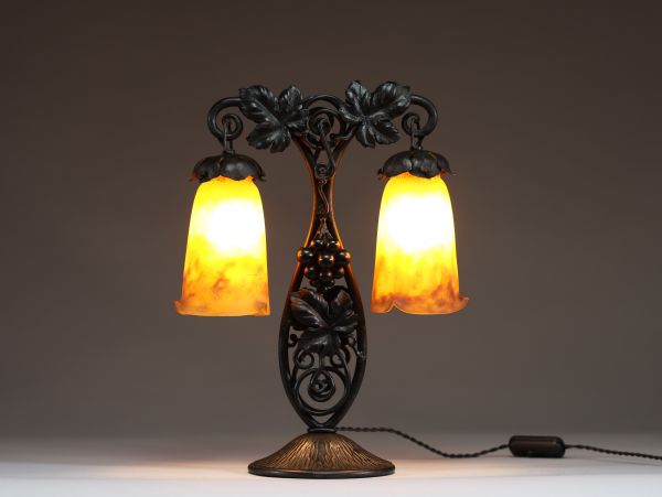 MULLER Frères Lunéville - Lampe de table Art Nouveau à double éclairage, montures en fer forgé à décor de vigne, verre marmoréen orangé, signée Muller Frès Lunéville.