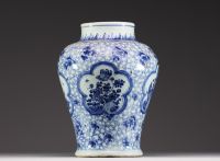 China - A white-blue porcelain baluster vase decorated with flowers, mugwort leaf mark within a double circle, Kangxi.