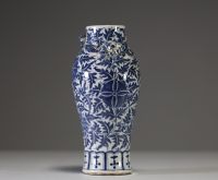 China - A white-blue porcelain vase decorated with flowers and foliage, chilong in relief on the shoulder, 19th century.