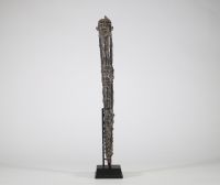 Hache cérémonielle en bronze à riche décor animalier – Afrique, probablement Congo, XXe siècle Hache cérémonielle coulée en bronze à patine foncée, ornée d’un décor finement ciselé figurant une tête anthropomorphe au sommet du manche, et une lame en forme de tranchant rectangulaire ajouré, décoré de motifs concentriques. Le fût présente une remarquable composition en relief représentant une faune
