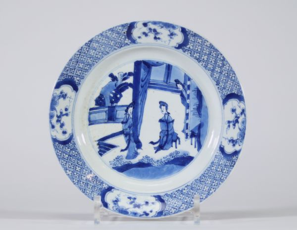 Assiette en porcelaine de Chine bleu blanc à décor de femmes au jardin, XVIIIe siècle Porcelaine fine à décor peint en bleu sous couverte représentant une scène animée dans un jardin avec trois figures féminines Marque apocryphe au revers en caractères kaishu : 