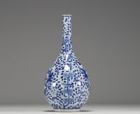 China - White-blue porcelain vase decorated with a figure holding a large covered vase, double circle mark under the piece.