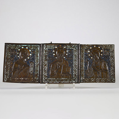 Icône de voyage Déésis en bronze émaillé, Russie, XVIIIᵉ–XIXᵉ siècle Icône triptyque en bronze à patine brune, décorée à l’émail champlevé bleu, blanc et turquoise, représentant une Déésis : au centre, le Christ Pantocrator bénissant et tenant les Évangiles ouverts, entouré à gauche de la Vierge Marie et à droite de saint Jean-Baptiste, dans une posture d’intercession.  Les trois volets, articulés