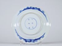 Assiette en porcelaine de Chine bleu blanc à décor de femmes au jardin, XVIIIe siècle Porcelaine fine à décor peint en bleu sous couverte représentant une scène animée dans un jardin avec trois figures féminines Marque apocryphe au revers en caractères kaishu : 