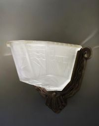 A pair of Art Deco sconces in pressed moulded glass with geometric motifs and silvered bronze mountings, circa 1930.