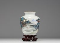 Chine - Vase en porcelaine polychrome à décor de paysage, socle en bois, marque au bleu sous la pièce.