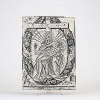 Rare ensemble de deux planches gravées en bois, probablement destinées à l’impression d’images religieuses issues de l’Imagerie d’Épinal. La première représente une Pietà entourée des instruments de la Passion, encadrée d’une mandorle foisonnante de détails gothiques. La seconde illustre le martyre de saint Sébastien, attaché à un tronc de palmier dans un décor boisé, un village médiéval en arrièr