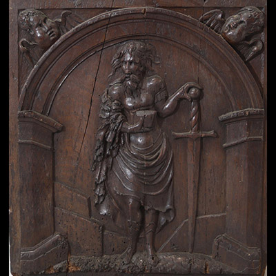 Panneau sculpté en chêne figurant saint Paul apôtre et martyr debout sous une arche architecturée. Deux têtes d’anges en fort relief ornent les écoinçons supérieurs travail flamand, probablement fin XVIe - début XVIIe siècle