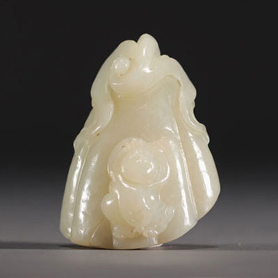 Chine - Pendentif en Jade blanc sculpté en forme de fruit surmonté d'un jeune enfant.
