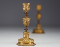 A pair of 19th century gilt bronze candlesticks, decorated with antique figures and goat heads.