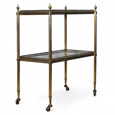 Desserte à deux plateaux attribuée à la Maison Jansen, vers 1940 Élégante desserte en métal doré à deux plateaux en miroir au mercure vieilli, montée sur roulettes. L’ensemble présente une structure à colonnettes cannelées surmontées de prises en toupie, typique des productions de la Maison Jansen dans les années 1940. Un meuble raffiné aux proportions équilibrées, mêlant fonctionnalité et style n