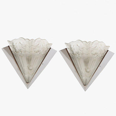 France, vers 1930 Paire d’appliques Art Déco à plaques de verre pressé signées Noverdy, monture en métal chromé.  Ces élégantes appliques murales, typiques de la production française des années 1930, présentent une plaque de verre moulé-pressé en forme de triangle inversé, à décor dépoli stylisé de feuillages et de volutes géométriques en relief. Ce motif, d’une grande finesse, évoque les formes v