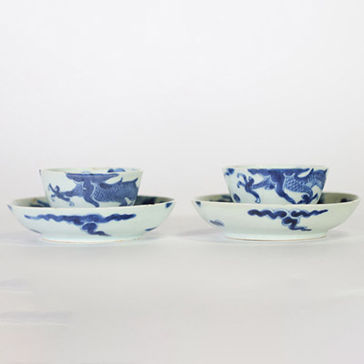 Chine, dynastie Qing – Ensemble de quatre bols et soucoupes en porcelaine bleu et blanc à décor de dragons parmi les nuées