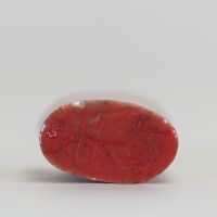 Sceau chinois ancien en pierre dure veinée, gravé à la base de caractères stylisés en rouge  Sceau chinois en pierre naturelle, de forme légèrement bombée, à pâte veinée de tons bruns et orangés. La b