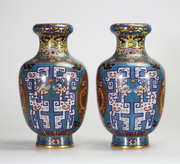 Rare paire de vases en cloisonné à décor de dragons affrontés dans des médaillons et motifs archaïsants, Chine, dynastie Qing, XIXe siècle Paire de vases balustres en laiton finement ornés d’émaux cloisonnés polychromes sur fond bleu turquoise, décorés de médaillons circulaires figurant des dragons affrontés sur fond rouge orné de nuées, encadrés de motifs archaïsants en registres, frises de ruyi,