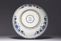 China - Large blue-white porcelain dish decorated with flowers and figures, Kangxi mark in a double circle.