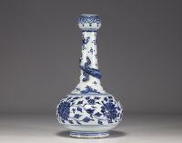 China - A white-blue porcelain vase decorated with a chimera in relief winding around the neck and floral motifs, 18th century.
