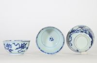 Chine, trois bols en porcelaine bleu et blanc, dynastie Qing, XVIIIe siècle, décorés de fleurs et symboles bouddhiques en léger relief au bleu sous couverte, l’intérieur orné d’une fleurette stylisée.
