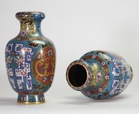Rare paire de vases en cloisonné à décor de dragons affrontés dans des médaillons et motifs archaïsants, Chine, dynastie Qing, XIXe siècle Paire de vases balustres en laiton finement ornés d’émaux cloisonnés polychromes sur fond bleu turquoise, décorés de médaillons circulaires figurant des dragons affrontés sur fond rouge orné de nuées, encadrés de motifs archaïsants en registres, frises de ruyi,