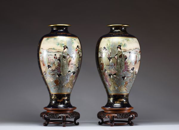 Japon - Grande paire de vases en porcelaine à décor en cartouche de jeunes femmes et d'enfants, reposant sur des socles en bois d'époque Meiji, XIXe siècle.