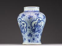 China - A white-blue porcelain baluster vase decorated with flowers, mugwort leaf mark within a double circle, Kangxi.