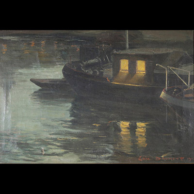 Edmond Doumont (1879–1954)  Huile sur toile, datée 1919  Réalisée en 1919, cette huile sur toile signée d’Edmond Doumont (1879–1954) témoigne d’une maîtrise remarquable du clair-obscur. L’œuvre met en scène une péniche éclairée, glissant doucement sur une étendue d’eau sombre. Le contraste entre la lumière chaude émanant de l’embarcation et l’opacité de l’environnement aquatique crée une atmosphèr