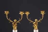 A pair of ormolu candelabra with cherubs and two arms, alabaster base, Napoleon III period.