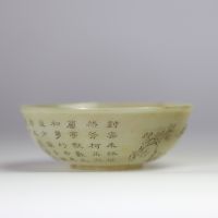 Bol en jade céladon finement gravé d’un paysage montagneux et d’un poème calligraphié, marqué Qianlong  Bol circulaire en jade de teinte céladon très pâle, finement incisé d’un décor continu représent