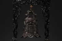 Chine - Cloche en bronze surmontée d'un dragon, supportée par un socle en bois sculpté, vers 1900.