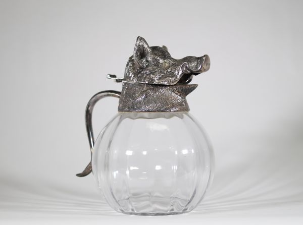 Valenti, Espagne, vers 1960 Aiguière en verre soufflé et monture en métal argenté à décor de sanglier.  Remarquable aiguière à panse godronnée en verre transparent, coiffée d’un couvercle sculptural en métal argenté figurant avec réalisme une tête de sanglier, gueule entrouverte et oreilles dressées.