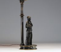 Bronze lamp depicting an antique woman leaning against a column, black marble base.