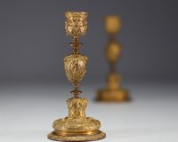 A pair of 19th century gilt bronze candlesticks, decorated with antique figures and goat heads.