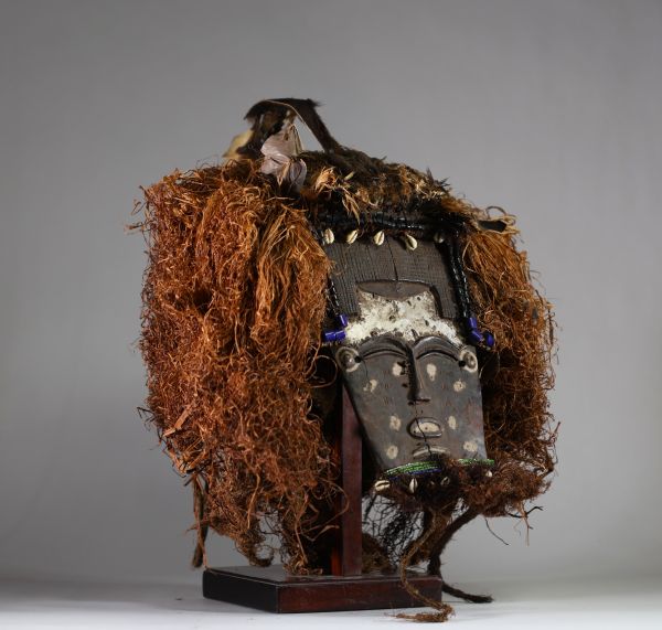 Rare masque Lele ( Bashilele) d’une grande complexité matérielle et stylistique, RD Congo. Bois, raphia, terre, perles, plumes et peau d’animal.  La patine est ancienne et riche, résultant d’une longue utilisation tribale, comme en témoigne également les réparations indigènes sur le visage. La forme du visage est classique. Les ornements sont multiples et extrêmement symboliques. Début XXème ou an