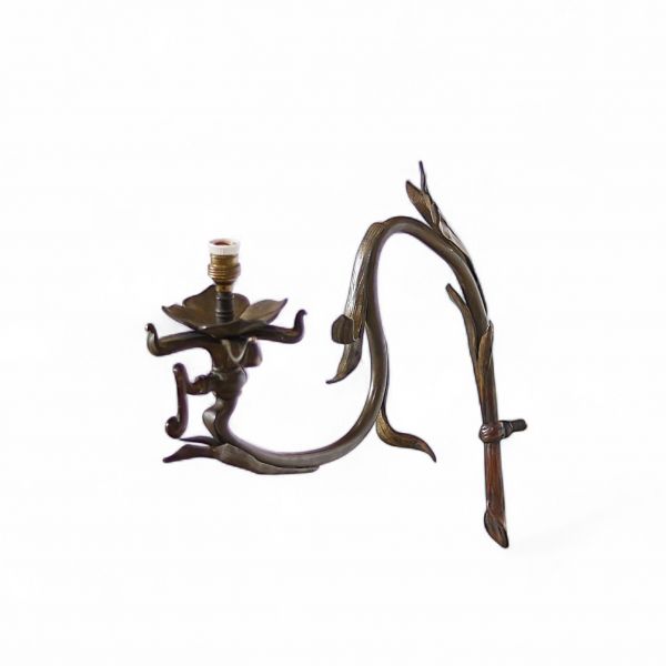 Applique à gaz Art nouveau – vers 1895–1905 Bronze ciselé à motif floral stylisé  Élégante applique murale à gaz en bronze, caractéristique du style Art nouveau, dont le dessin associe fonction et symbolisme dans une approche résolument organique. L’ensemble de la structure évoque une plante stylisée, où le robinet de gaz prend la forme sinueuse d’une tige végétale, se courbant délicatement pour s