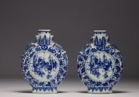 China - Pair of blue-white gourd vases decorated with figures at play, chimera handles, 19th century.