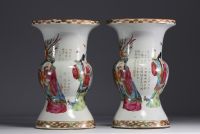 China - A pair of famille rose porcelain vases decorated with dignitaries, courtesans and poems, 19th century.