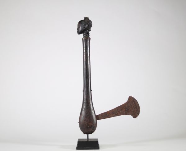 Herminette de prestige ornée d’une tête – Luba, RDC Herminette traditionnelle en bois et fer forgé, provenant du peuple Luba (République Démocratique du Congo). Le manche, finement sculpté, est orné d’une tête féminine stylisée