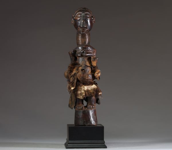 Afrique RDC - Fétiche Songye en bois sculpté, fer, peau et coquillages, Congo RDC, début XXème, sur socle.