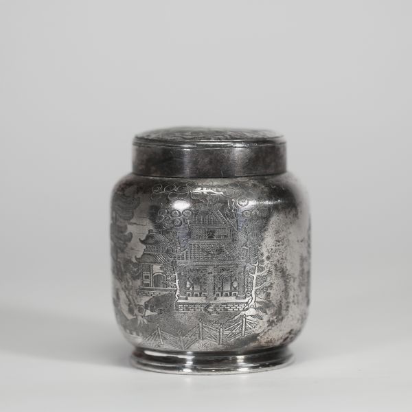 Chine, vers 1900 Pot à thé en argent massif gravé, à décor de paysages animés  Pot à thé de forme balustre en argent massif finement gravé d’un paysage traditionnel chinois, animé de scènes de village, pavillons, montagnes, oiseaux en vol et figures humaines. Le couvercle est orné d’un large chrysanthème stylisé dans un médaillon circulaire. La base est marquée au revers, vraisemblablement d’un or